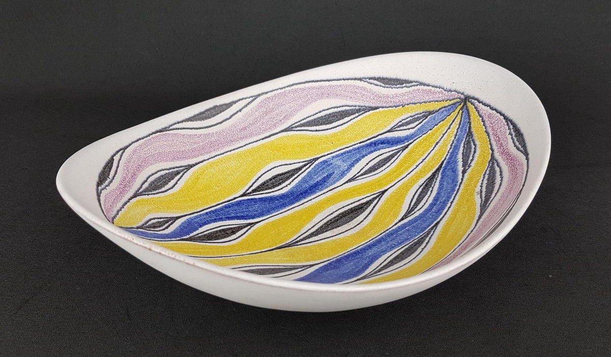 A white bowl with a colorful, abstract design featuring yellow, blue, and pink stripes and swirls.