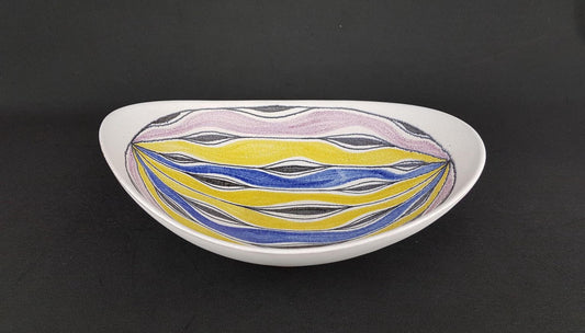 A white bowl with a colorful, abstract design featuring yellow, blue, and purple lines and shapes.
