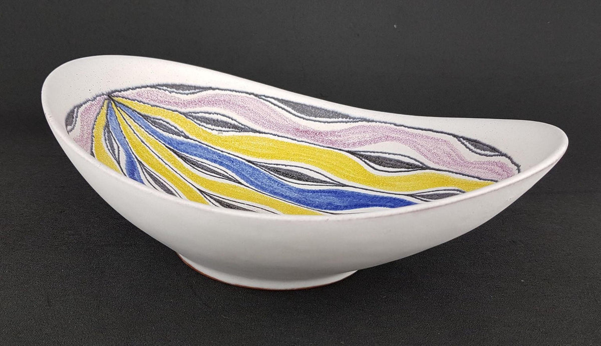 A white ceramic bowl with a colorful abstract design featuring yellow, blue, and purple lines.